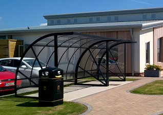 Bi-Store™ Cycle Shelter in use outside a hotel next to a Glasdon Jubilee™ Litter Bin