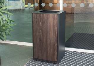 Nexus® Style 85 Duo Recycling Bin with a dark teak vinyl wrap in a hotel lobby