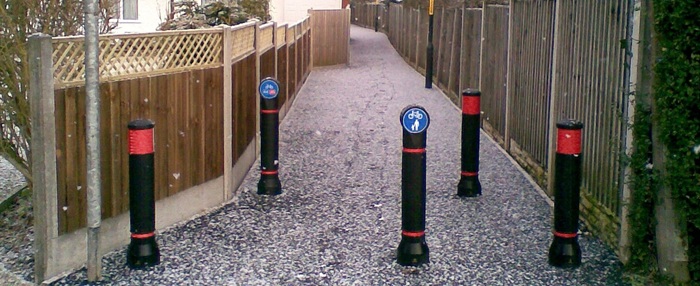 an assortment of bollards in an urban area on a pedestrian path