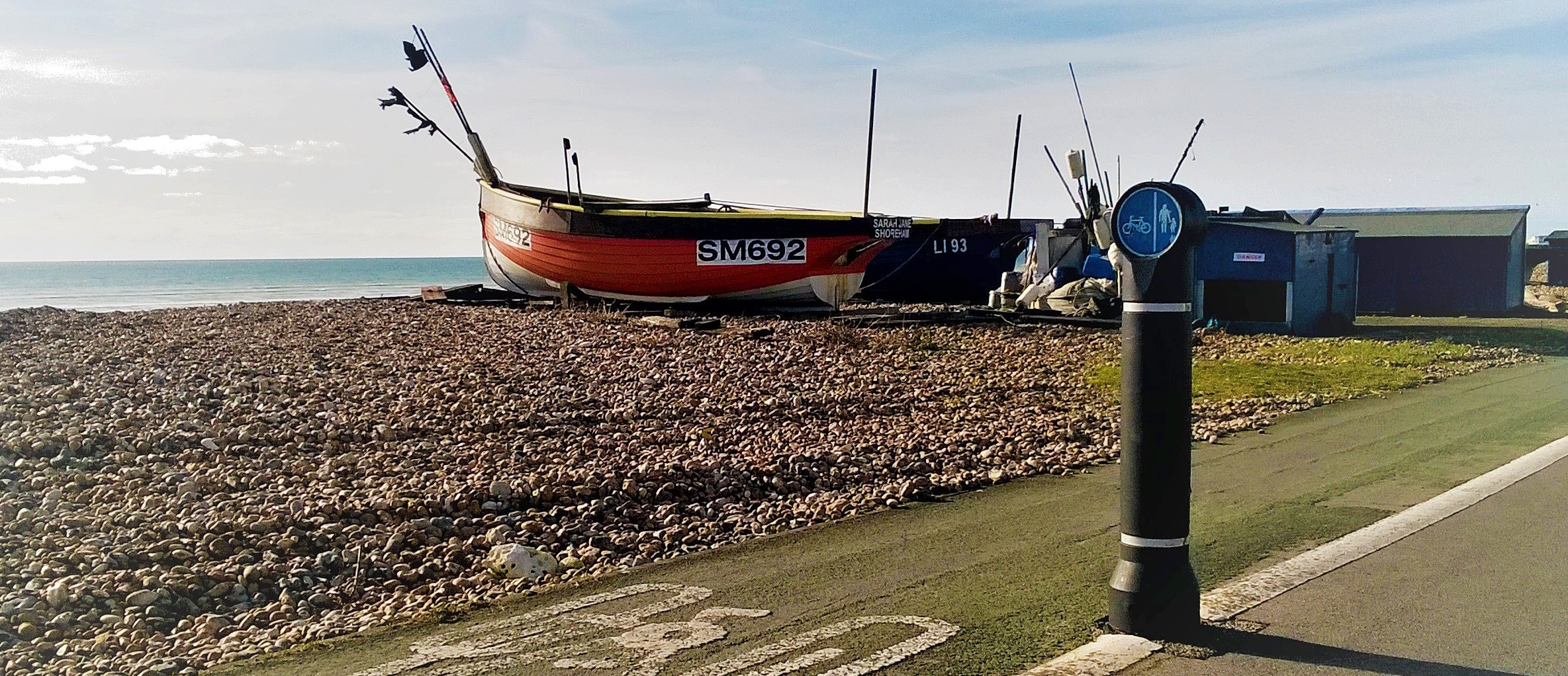 bollard at the coast with a beach and a shipwreck in the background