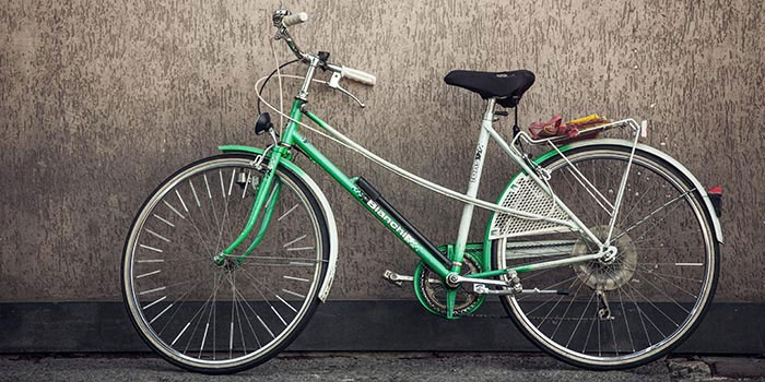 green bicycle propped against the wall