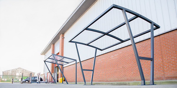 Cadence Cycle Shelter and Strada Cycle Shelter fixed to concrete outside building