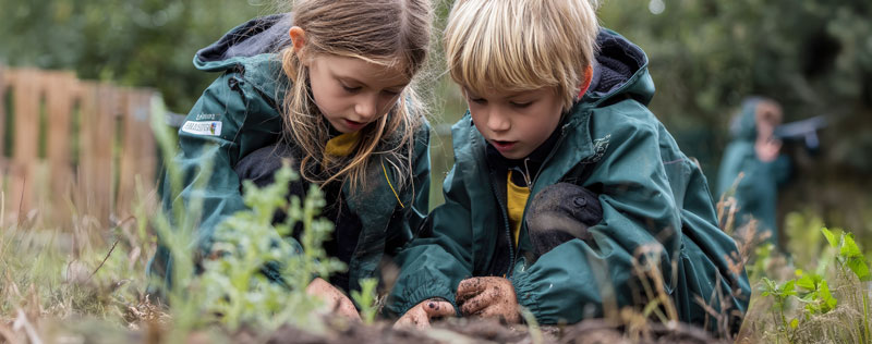 primary school children learning in an outdoor garden setting