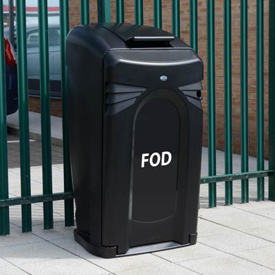 black FOD 140 bin with closeable lid outdoors next to a metal fence