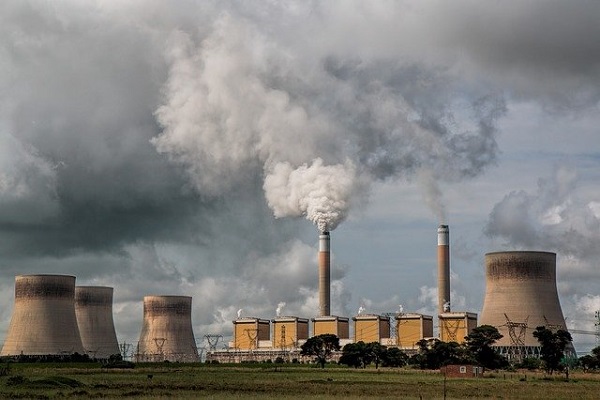Zoomed out image of a power station and billowing chimneys