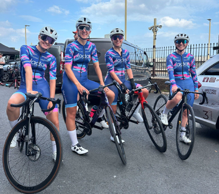 four team jadan cyclists posing on a street with their bikes